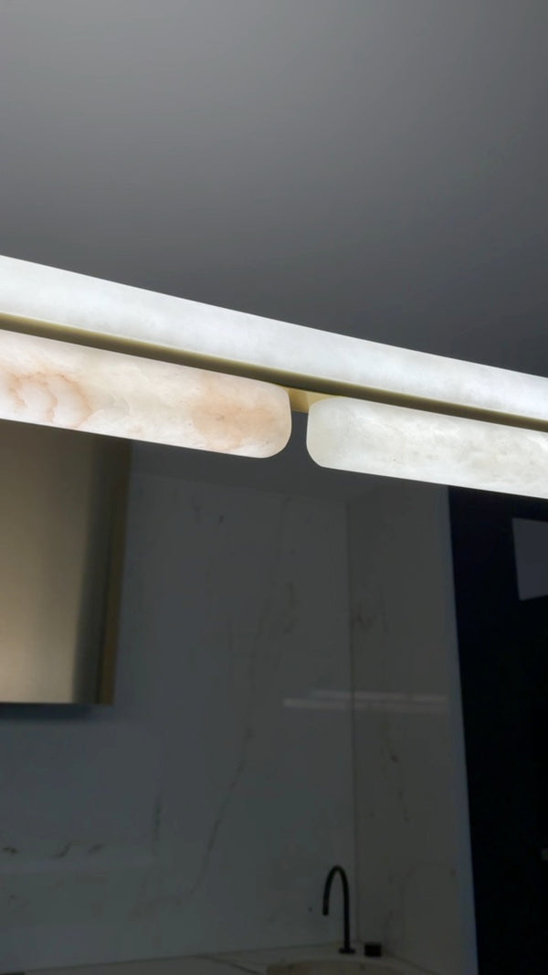 Alabaster linear pendant light over a marble kitchen